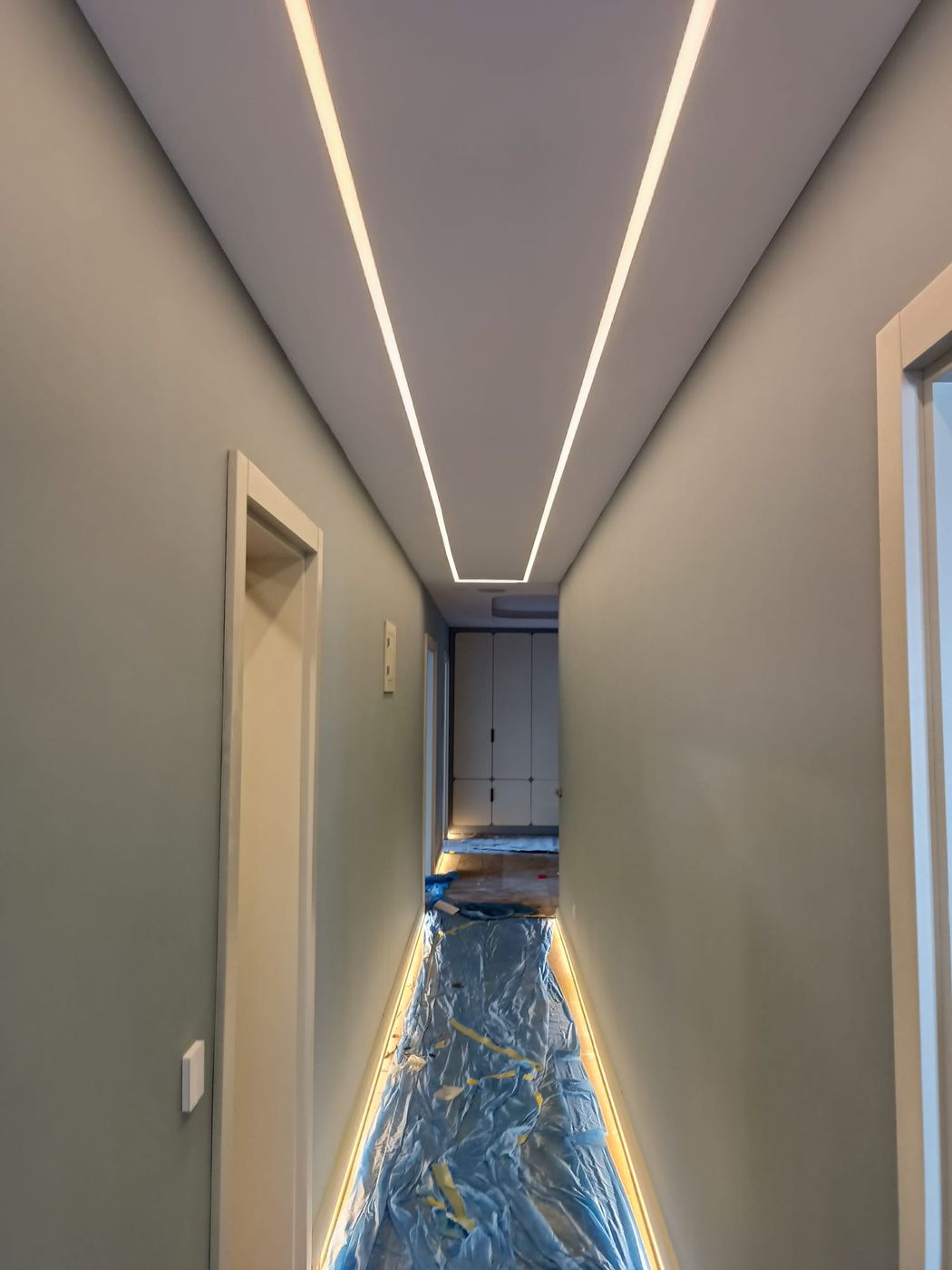 Tavanında çizgisel LED ışık olan uzun koridor