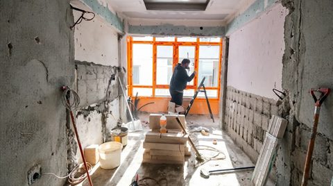 Sıvası dökülmüş duvarda turuncu bantlı pencere montajı